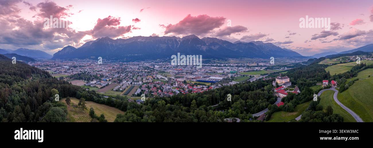 Panoramablick auf Innsbruck und das Inntal bei Sonnenuntergang, erfasst in dem Moment, in dem der westliche Himmel sich in tiefem Rosa verwandelt und die mächtige Nordke Stockfoto