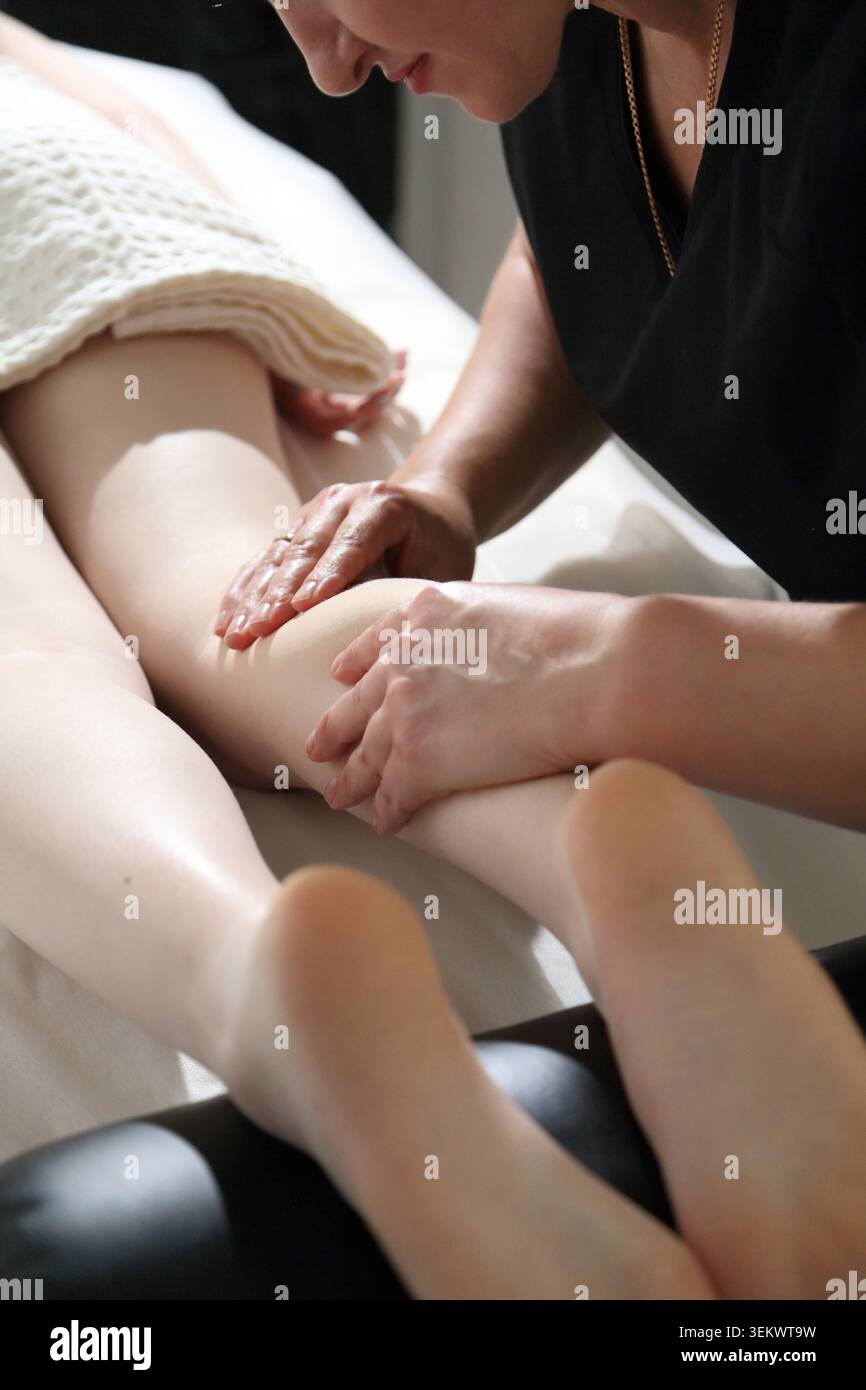 SPA-Salon und Massage. Massageraum. Spa. Ein Massagetherapeut arbeitet mit einer jungen Frau zusammen. Fuß- und Beinmassage. Stockfoto