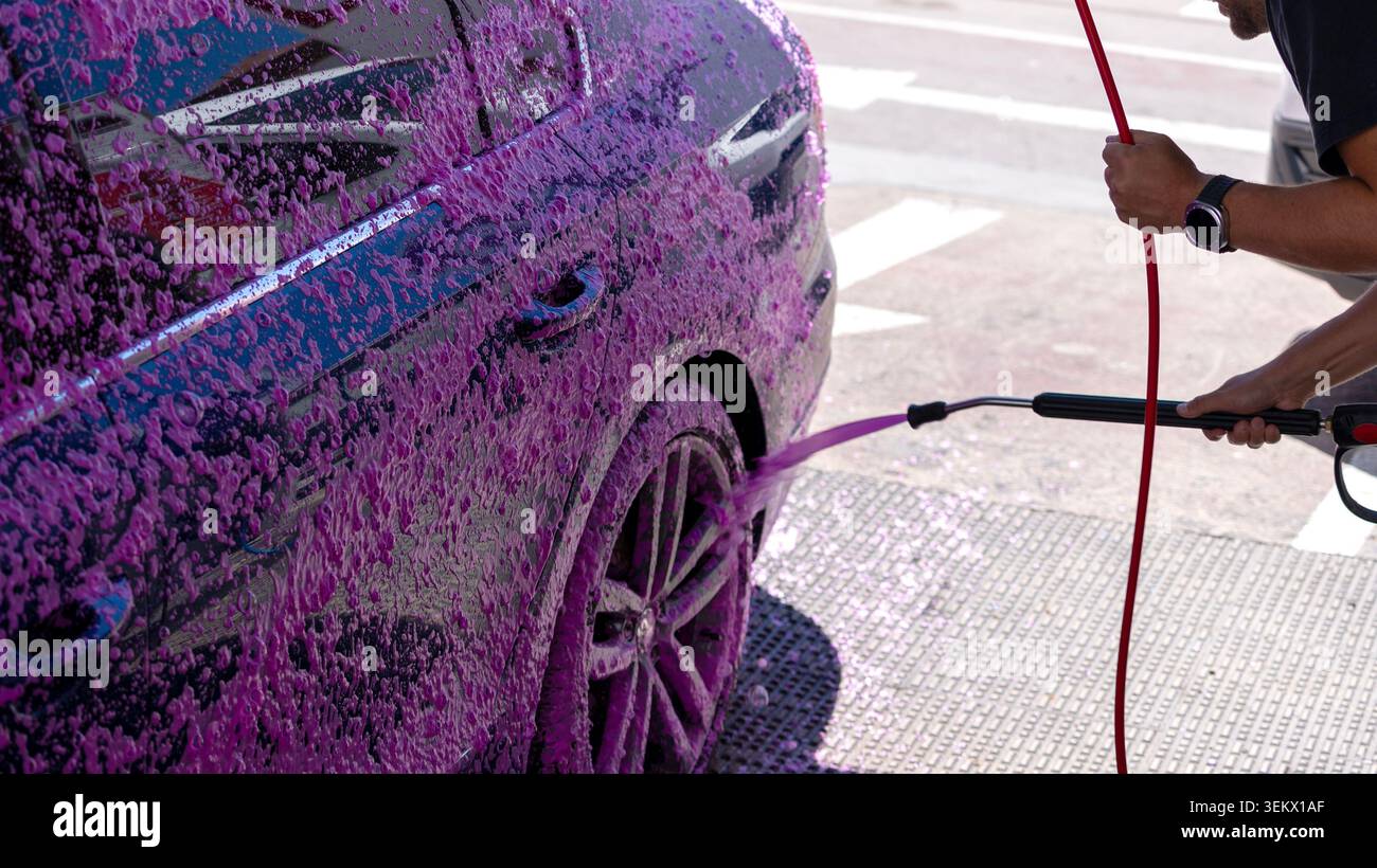 Auto bedeckt mit violettem Schaum während der Selbstbedienung Autowäsche Stockfoto
