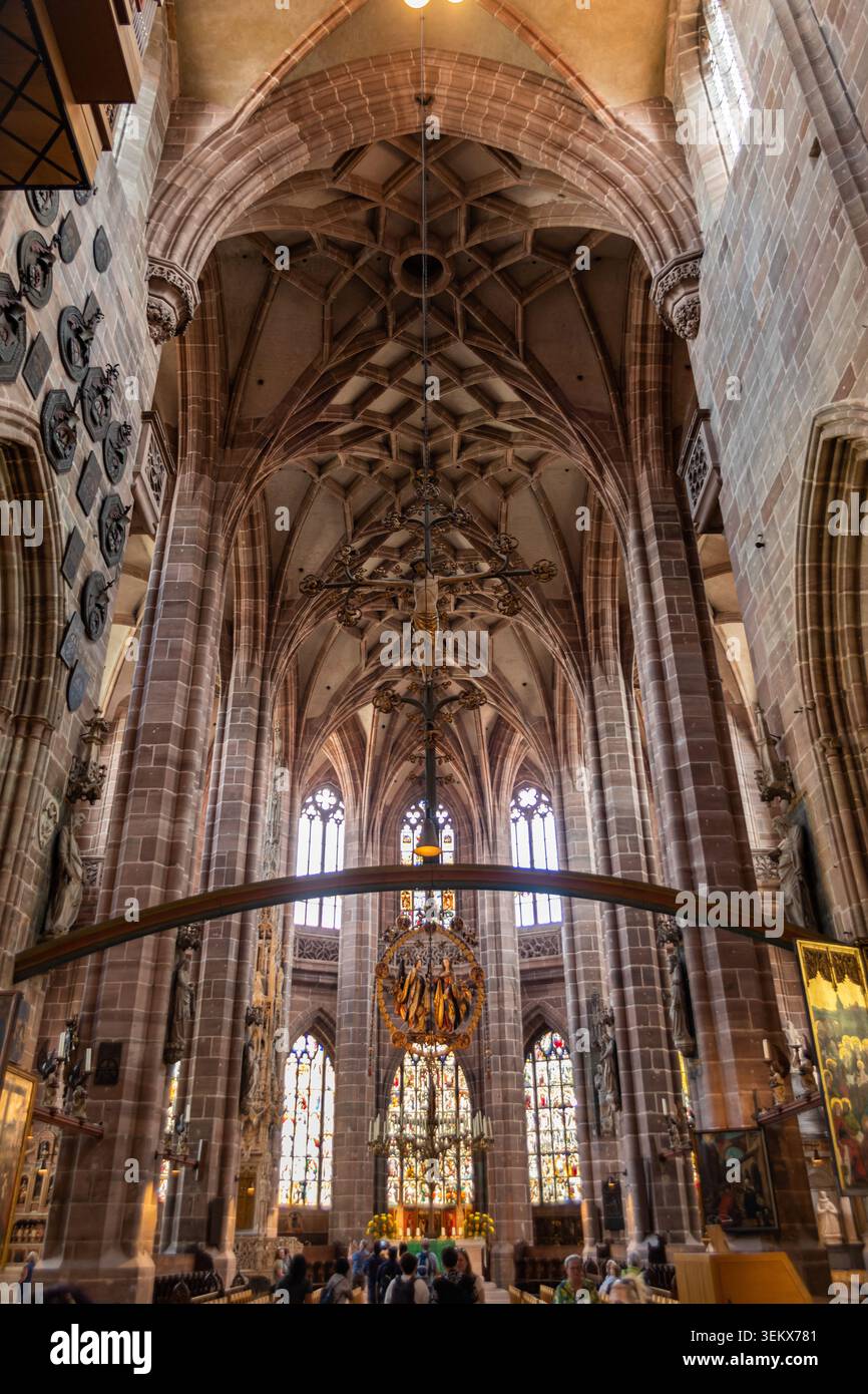 Majestätisches mittelalterliches Kircheninnere mit hohen gotischen Bögen, Rippengewölben und heiligen Kunstwerken unter historischen Decken. Stockfoto