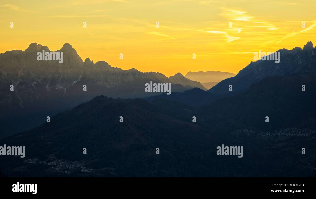 La Valle Agordina, Italien - 15.10.2021: Dramatische Alpenlandschaft mit mehrschichtigen Bergkämmen unter einem hellen goldenen Abendglühen Stockfoto