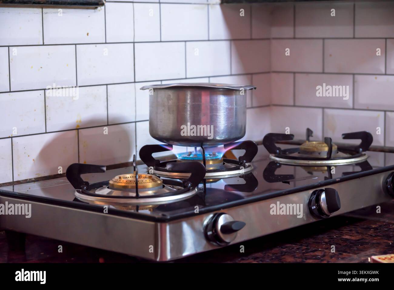 Nahaufnahme des blauen Feuers aus der Küche. Gaskocher mit brennenden Flammen von Propangas. Gasversorgungskette und Neuigkeiten. Globale Gaskrise Stockfoto