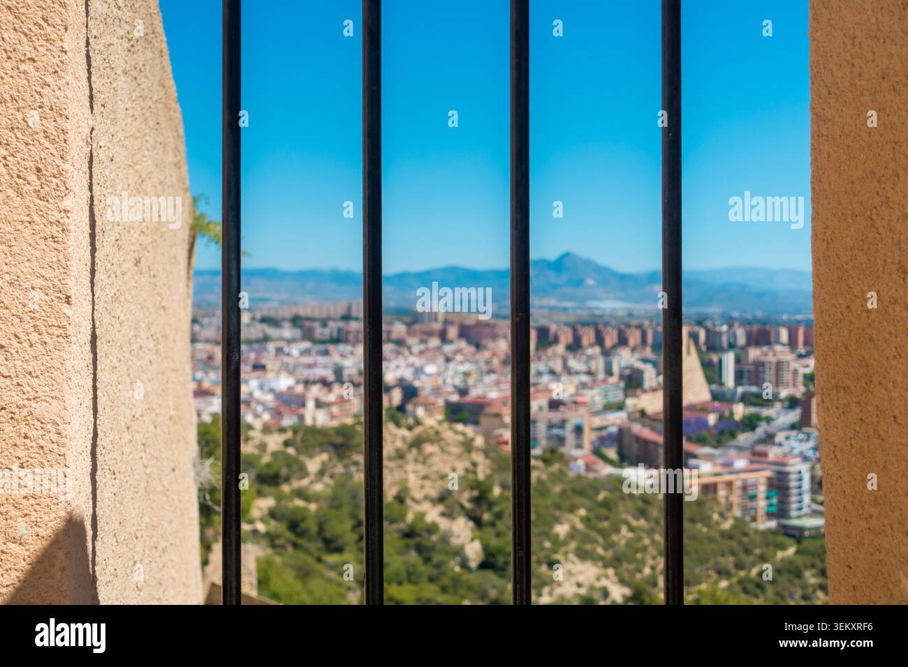 Geschützter Aussichtspunkt mit Metallzaun und Berg- und Stadtlandschaft im Hintergrund Stockfoto