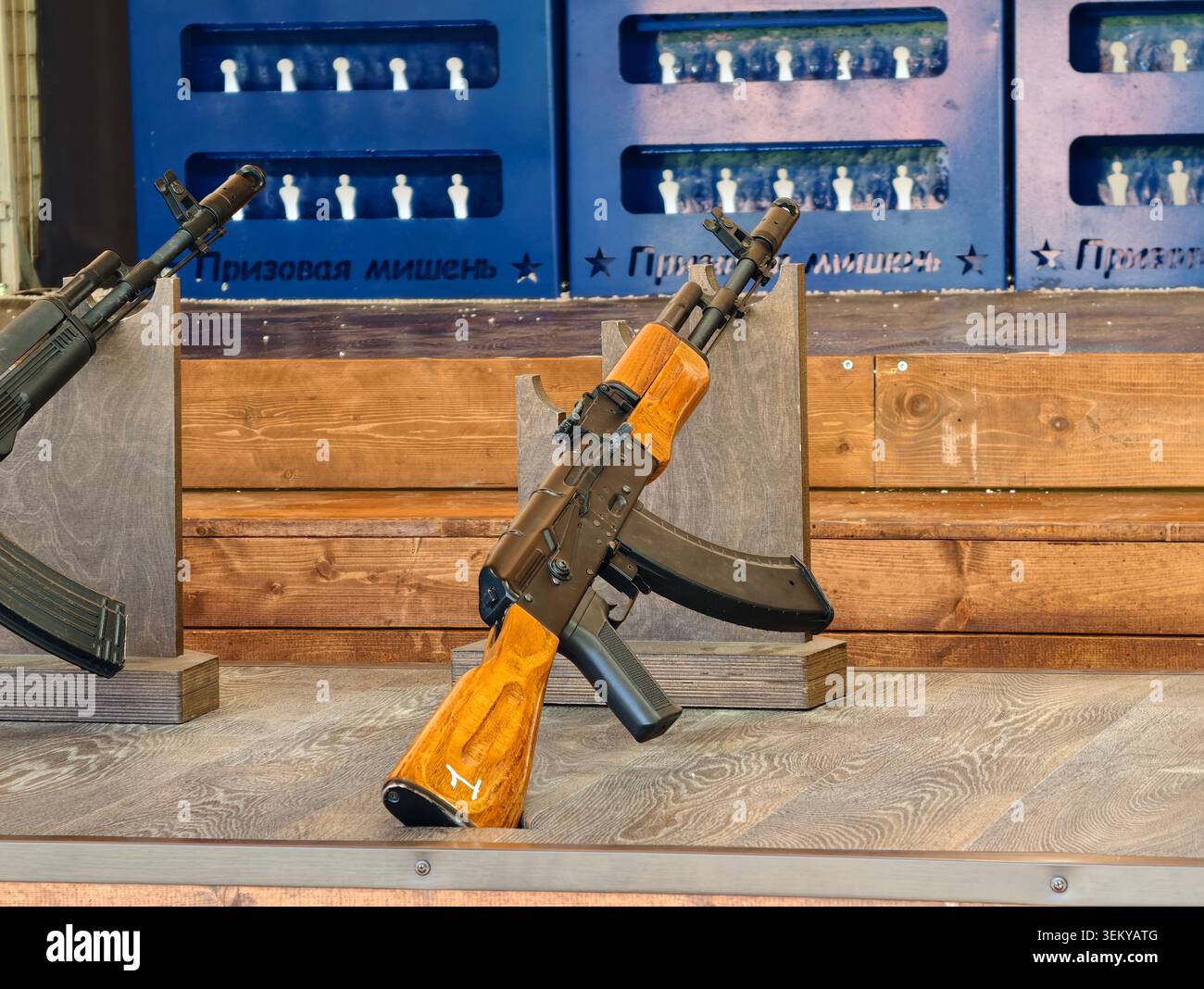 Ein Kalaschnikow AK-74 Luftgewehr auf einem hölzernen Schießstand für Kinder. Ziele in der Ferne mit der Aufschrift „Preisziel“ Stockfoto