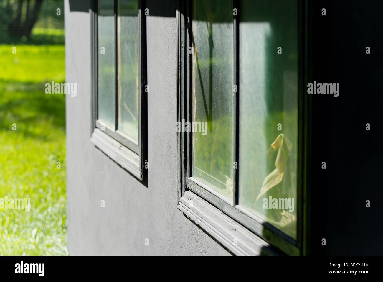 Architektonische Außendetails eines neu renovierten Wohnhauses mit sauberen Betonputzarbeiten und energieeffizienten Fensteruni Stockfoto