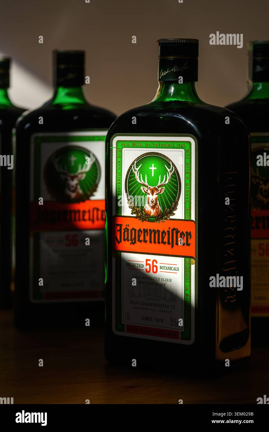 Novi Sad, Serbien - 4. April 2026: Nahaufnahme der Jägermeister-Flasche mit ikonischem Hirschetikett, das dramatisch auf dem Barregal beleuchtet wird. Stockfoto