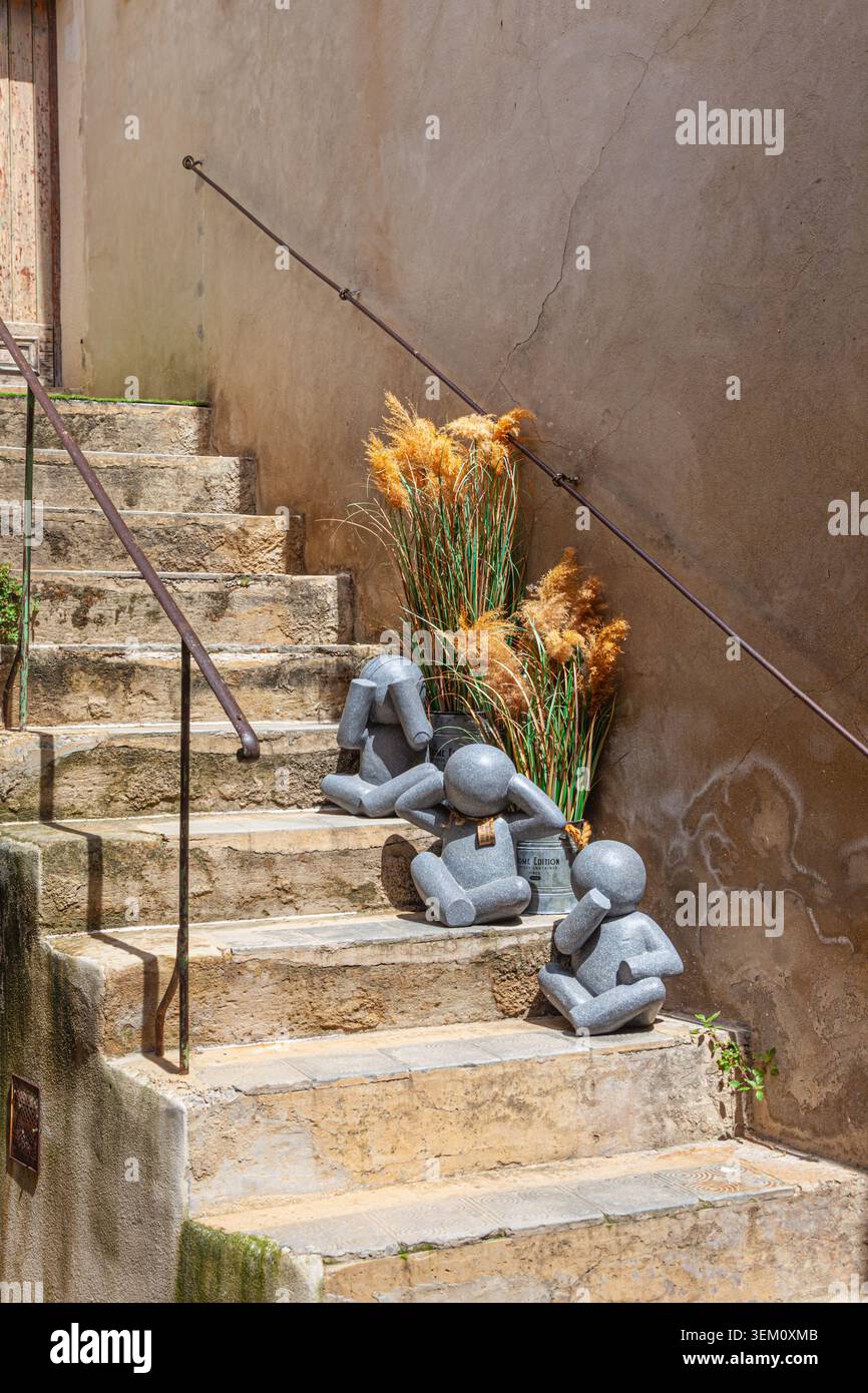 Graue Granitfiguren auf einer Treppe in Lourmarin in der französischen Provence Stockfoto