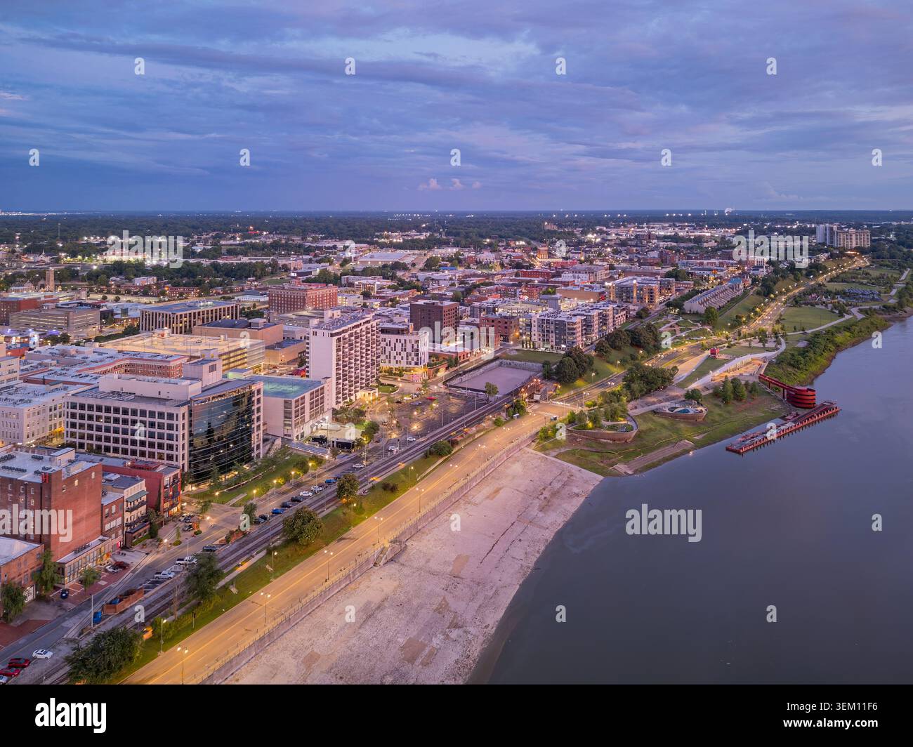 Blick auf die Stadtlandschaft von Memphis und den Park am Fluss entlang des Mississippi River mit beleuchteten Gebäuden und einem Pier in der Dämmerung. Stockfoto