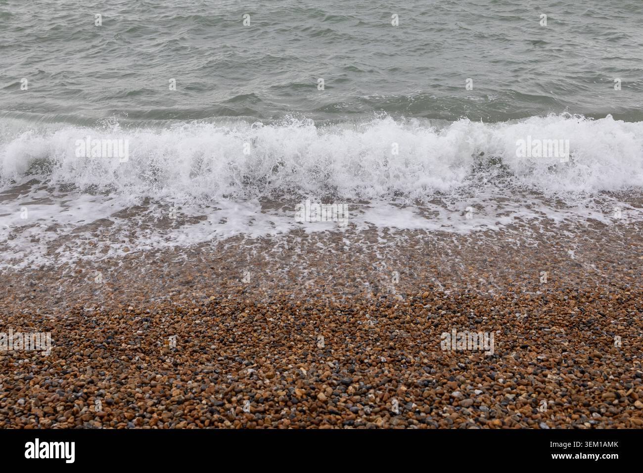 Wellen bremsen an einem Kieselstrand Stockfoto