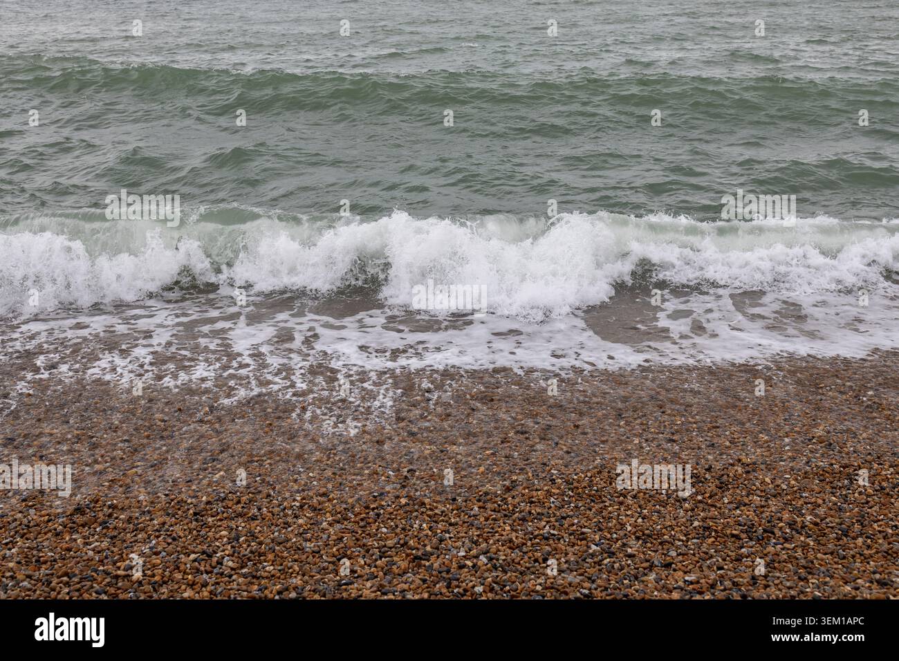 Wellen bremsen an einem Kieselstrand Stockfoto