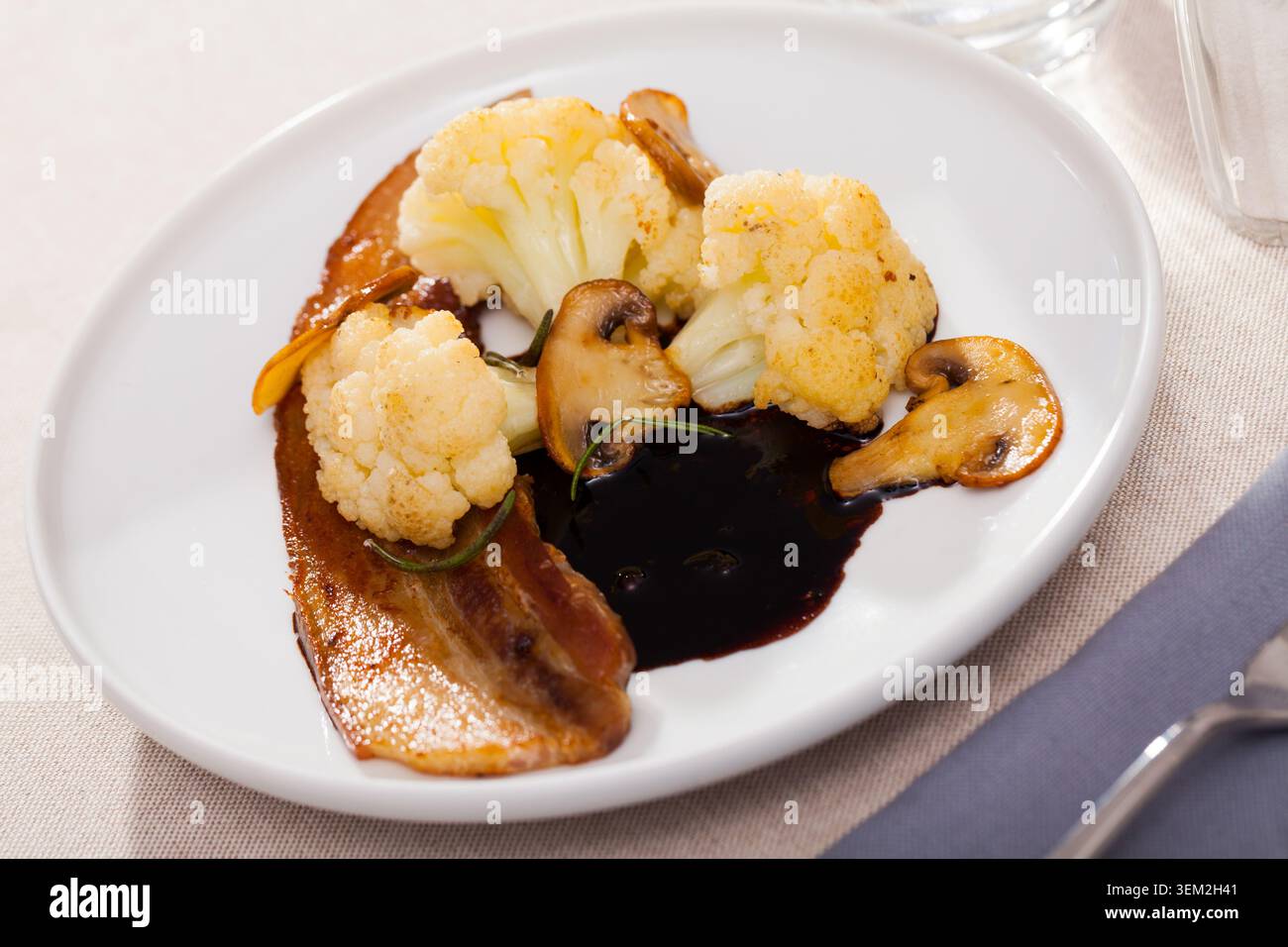 Blumenkohl mit gebratenem Schweinebauch und Pilzen Stockfoto