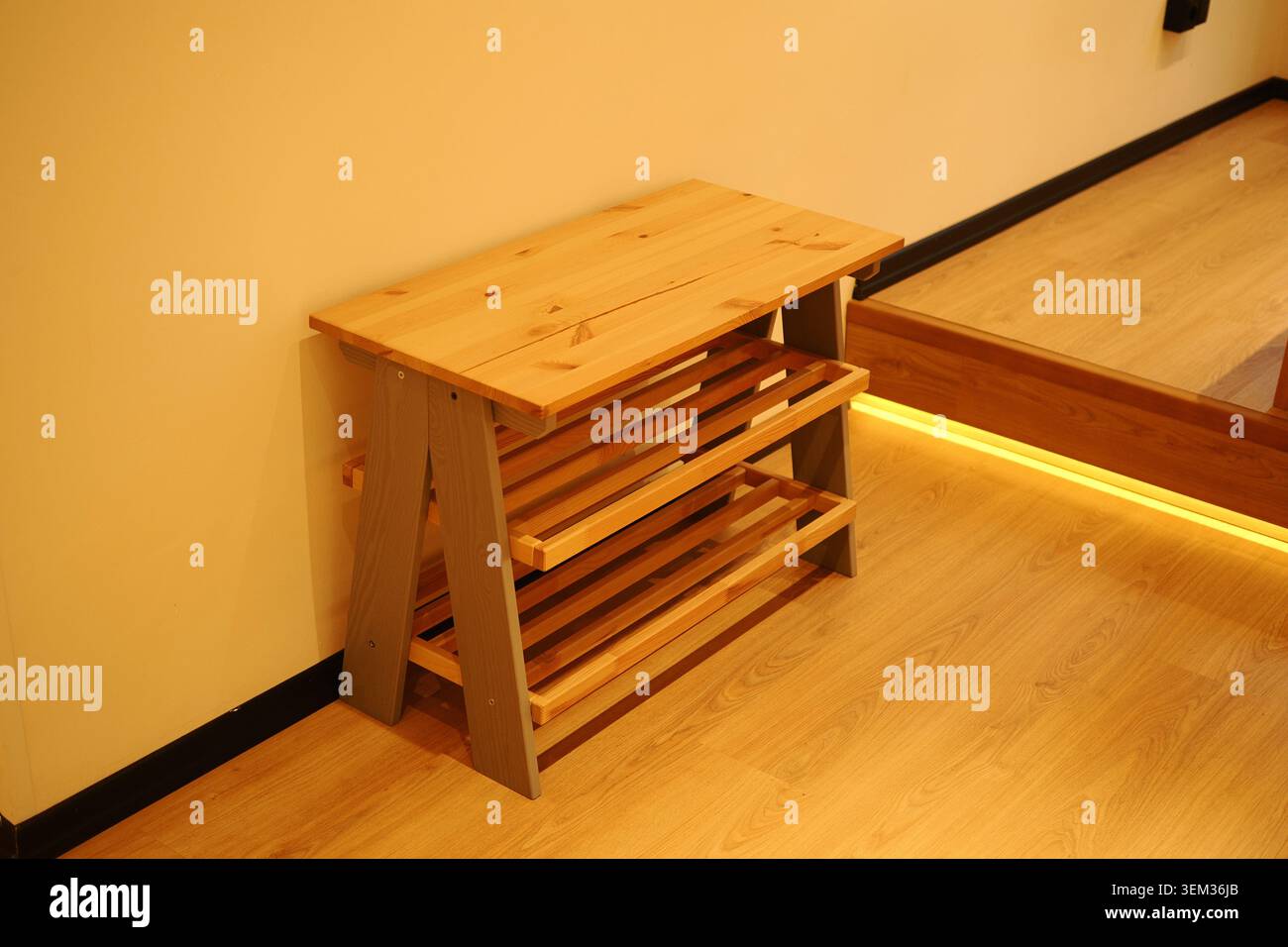 Holzregalständer, der an einer Wand in einem Raum aufgestellt wird Stockfoto