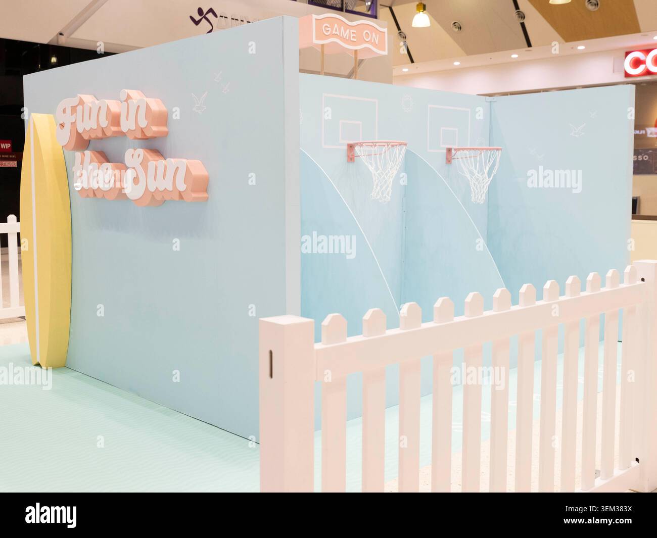 Eine leere Pop-up-interaktive Basketballspiel-Installation mit einem Streifenzaun und Surfbrettdekor in einem Einkaufszentrum in Queensland. Stockfoto