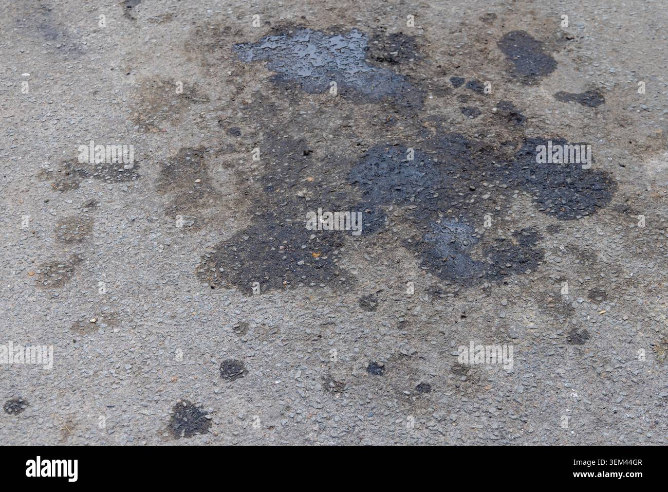 Schwarze Flecken Öl von Kraftfahrzeugen bei Asphalt Oberflächenschäden Verschmutzung Stockfoto