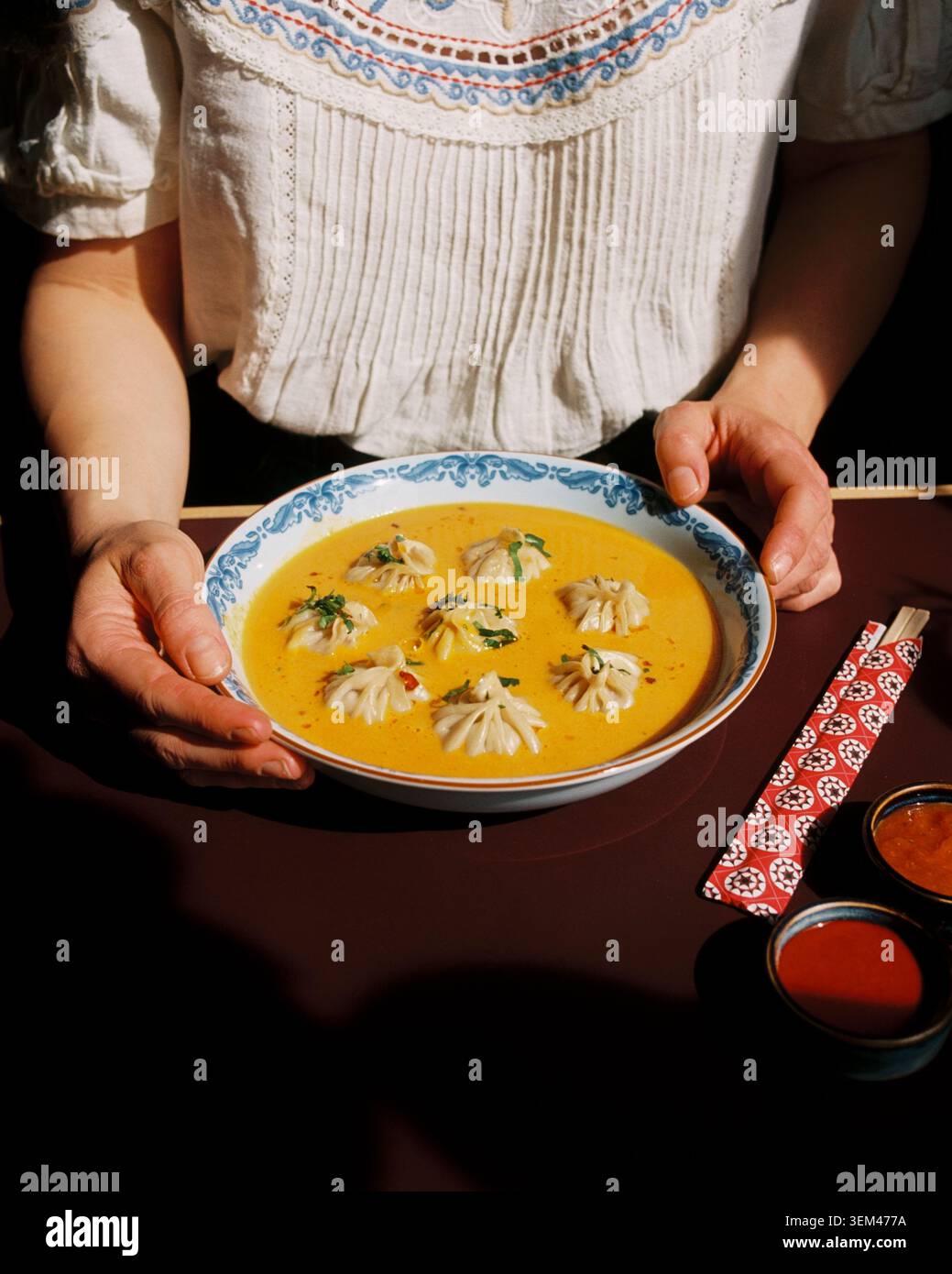 Eine Frau, die eine Schüssel mit leckerer Hymalayan-Suppe hält Stockfoto