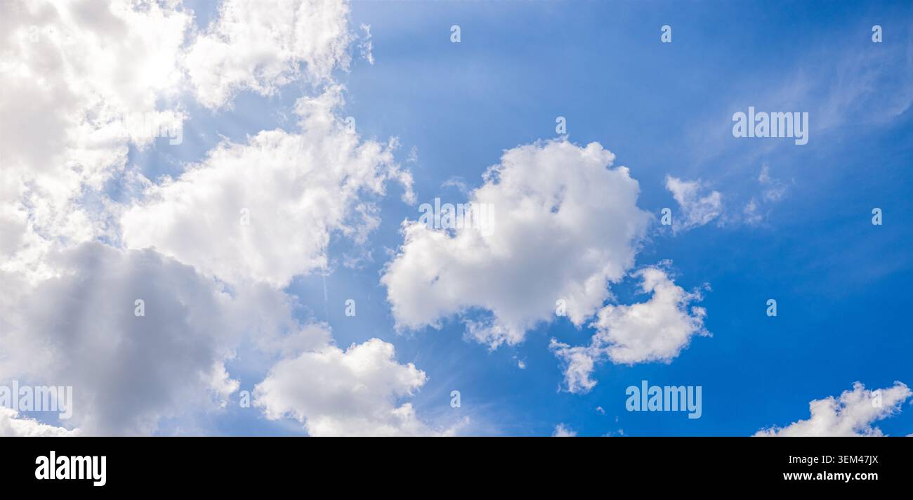 Heller blauer Himmel mit großen, flauschigen weißen Wolken an einem sonnigen Sommertag. Frisches Wolkenhimmels-Sonnenschein. Himmel-Wolken-Natur-Hintergrund Himmel Kopierraum friedlich Stockfoto