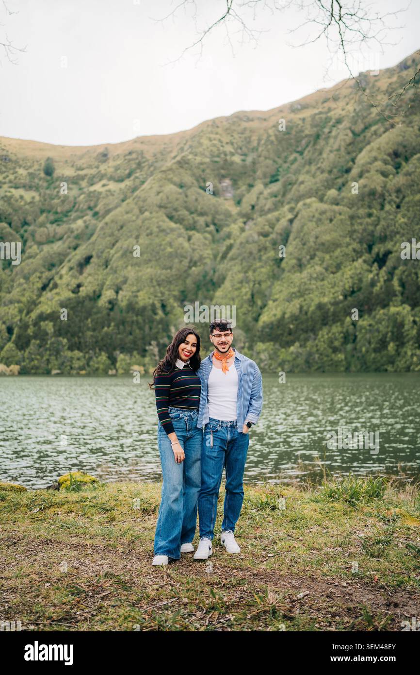 Lächelndes Paar, das an einer Bergsee-Landschaft steht Stockfoto