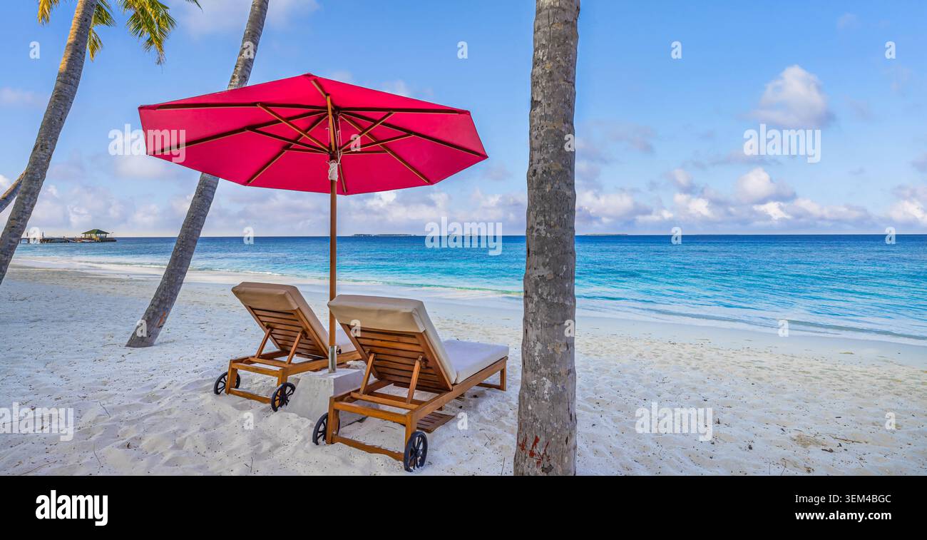 Romantischer roter Sonnenschirm Sonnenliegen türkisfarbener Lagunenstrand. Hohe Palmen schweben am weißen Sandstrand. Helles tropisches Paradies, Inselparadies mit blauem Himmel Stockfoto