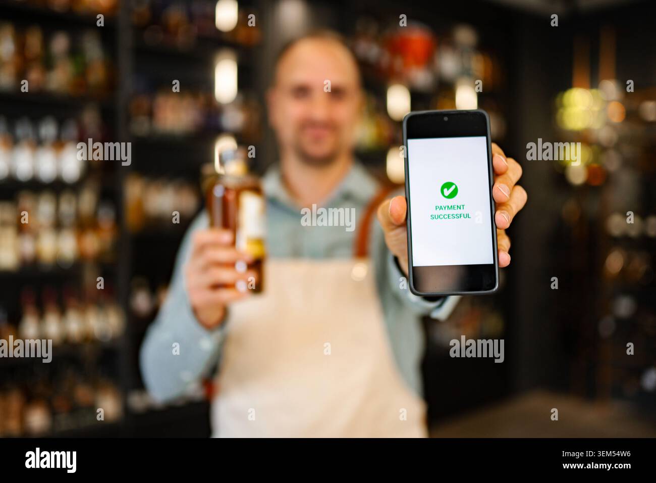 Ladenbesitzer zeigt eine erfolgreiche Nachricht mit Alkohol an Stockfoto