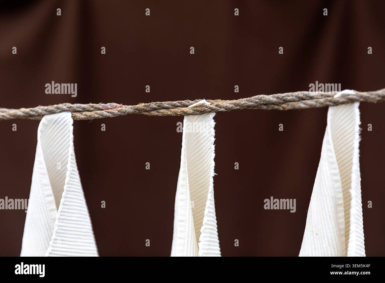 Eine Nahaufnahme weißer Kleidung, die an einem traditionellen Seil hängt, um sie in der historischen öffentlichen Wäscherei Dhobi Khana in Kochi, Kerala, Indien, zu trocknen Stockfoto