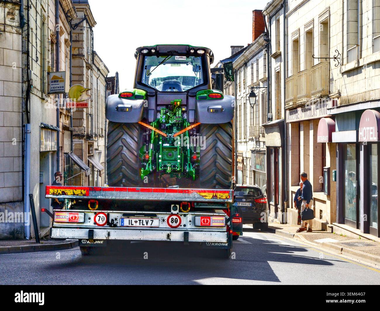 Österreichischer Tieflader mit Traktoren über die enge, zentrale französische Stadtstraße - Preuilly-sur-Claise, Indre-et-Loire (37), Frankreich. Stockfoto