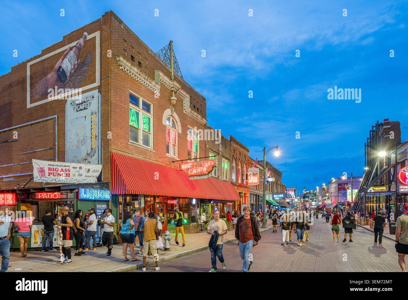 Memphis, Vereinigte Staaten, 23. Mai 2026 – Menschenmassen schlendern eine mit Ziegeln gepflasterte Straße entlang, die in der Innenstadt von beleuchteten Bars und Restaurants gesäumt ist Stockfoto