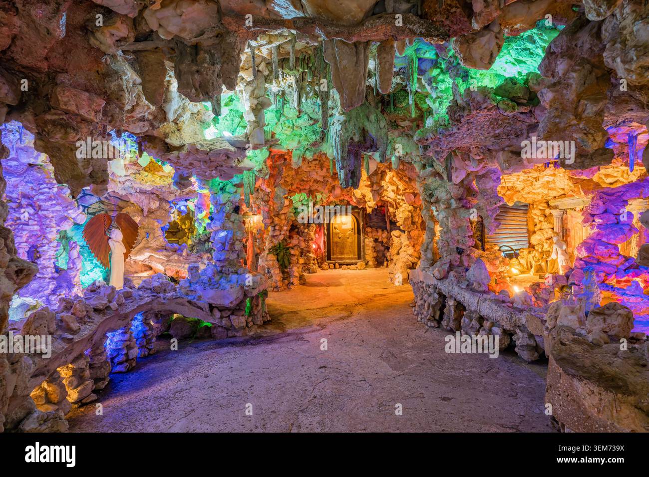 Memphis, Vereinigte Staaten, 24. MAI 2026 – Ein Weg durch eine von mehrfarbigen Lichtern beleuchtete Felsgrotte mit religiösen Statuen und einem zentralen Stockfoto