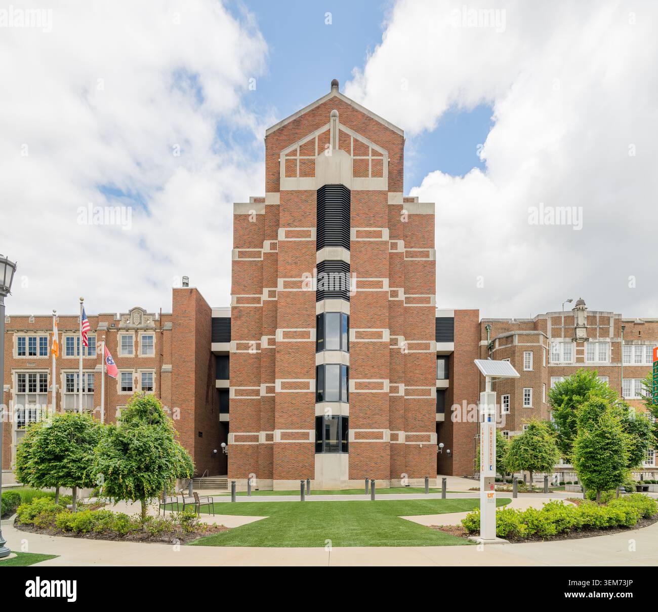 Memphis, Vereinigte Staaten, 24. Mai 2026 – Ein hohes rotes Backsteingebäude mit einem abgestuften Art-Deco-Turm und schwarzen vertikalen Akzenten steht auf einem Campusrasen Stockfoto