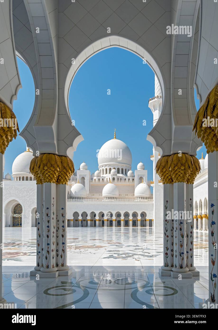 Ein Blick durch einen eleganten Marmorbogen, der in den Haupthof und in Richtung der zentralen Kuppeln führt, Scheich Zayed-Moschee, Abu Dhabi, VAE Stockfoto