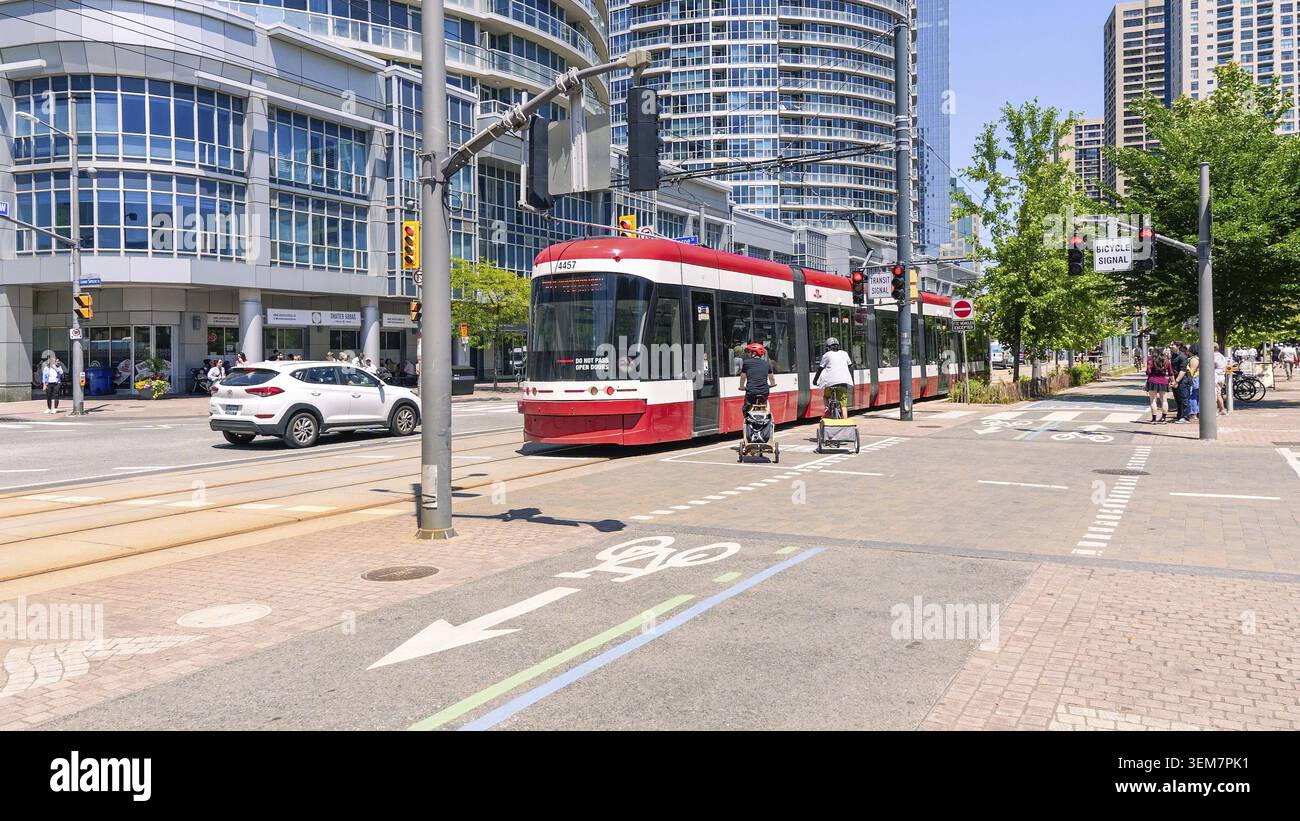 Toronto ON, Kanada - 29. Juni 2025: Die TTC-Straßenbahn fährt durch Toronto, umgeben von zeitgenössischer Architektur und Menschen, und hebt das Leben der Stadt hervor Stockfoto