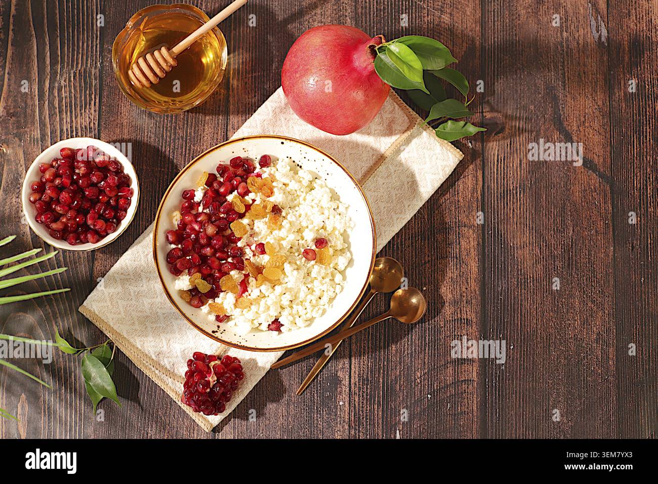 Körniger frischer Hüttenkäse mit Granatapfelsamen, Rosinen, Honig und Saft auf einem sonnigen Tisch, Entgiftungsdiät und natürliches Ernährungskonzept, gesundes LIFE Stockfoto