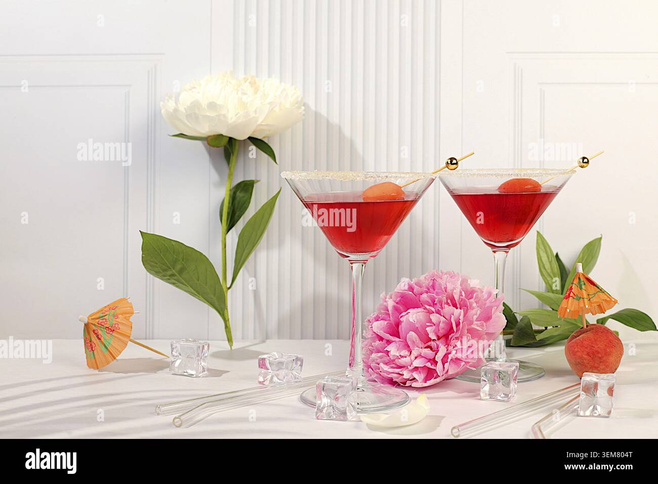 Modernes Stillleben mit rosafarbenem Martini, Sommer-alkoholischer Cocktail mit Aprikose für Party und Pfingstrosen auf elegantem modernem Hintergrund, minimalistisches Konzept für Stockfoto