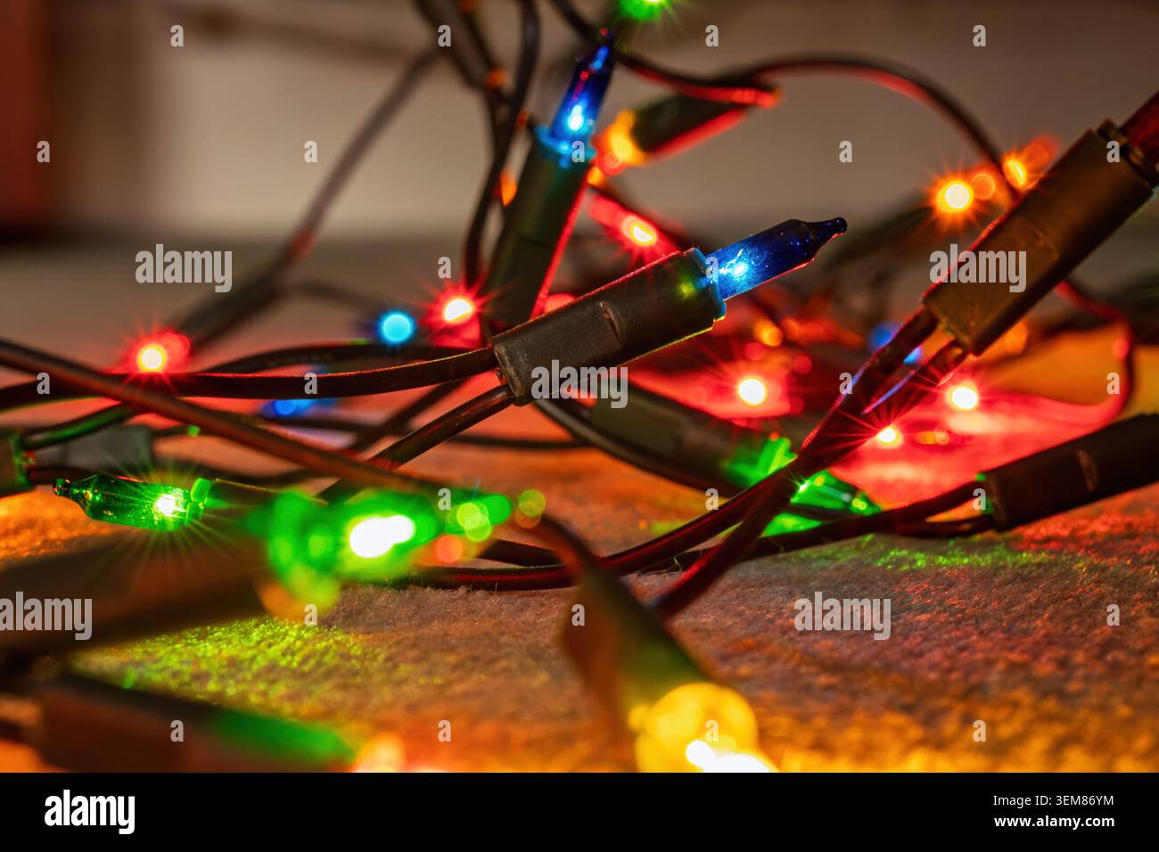 Nahaufnahme von beleuchteten Weihnachtslichtern, die während der Weihnachtsdekoration ein farbenfrohes, festliches Leuchten erzeugen Stockfoto