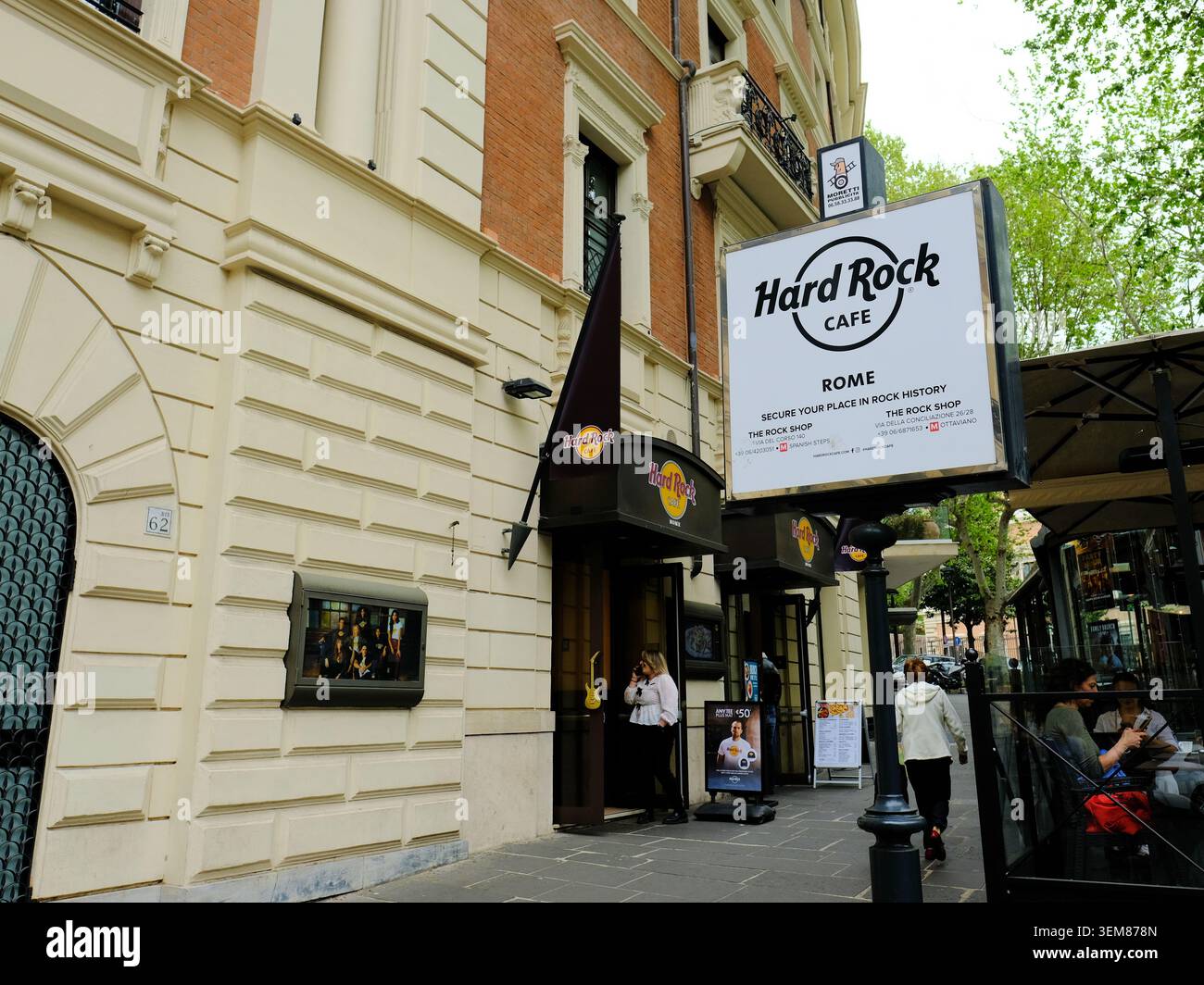 Außenschild am Eingang in der Nähe des Bürgersteigs, Terrasse, Abendessen und Tische im Hard Rock Cafe an der Via Veneto in Roma, Italien; Restaurants und Restaurants. Stockfoto