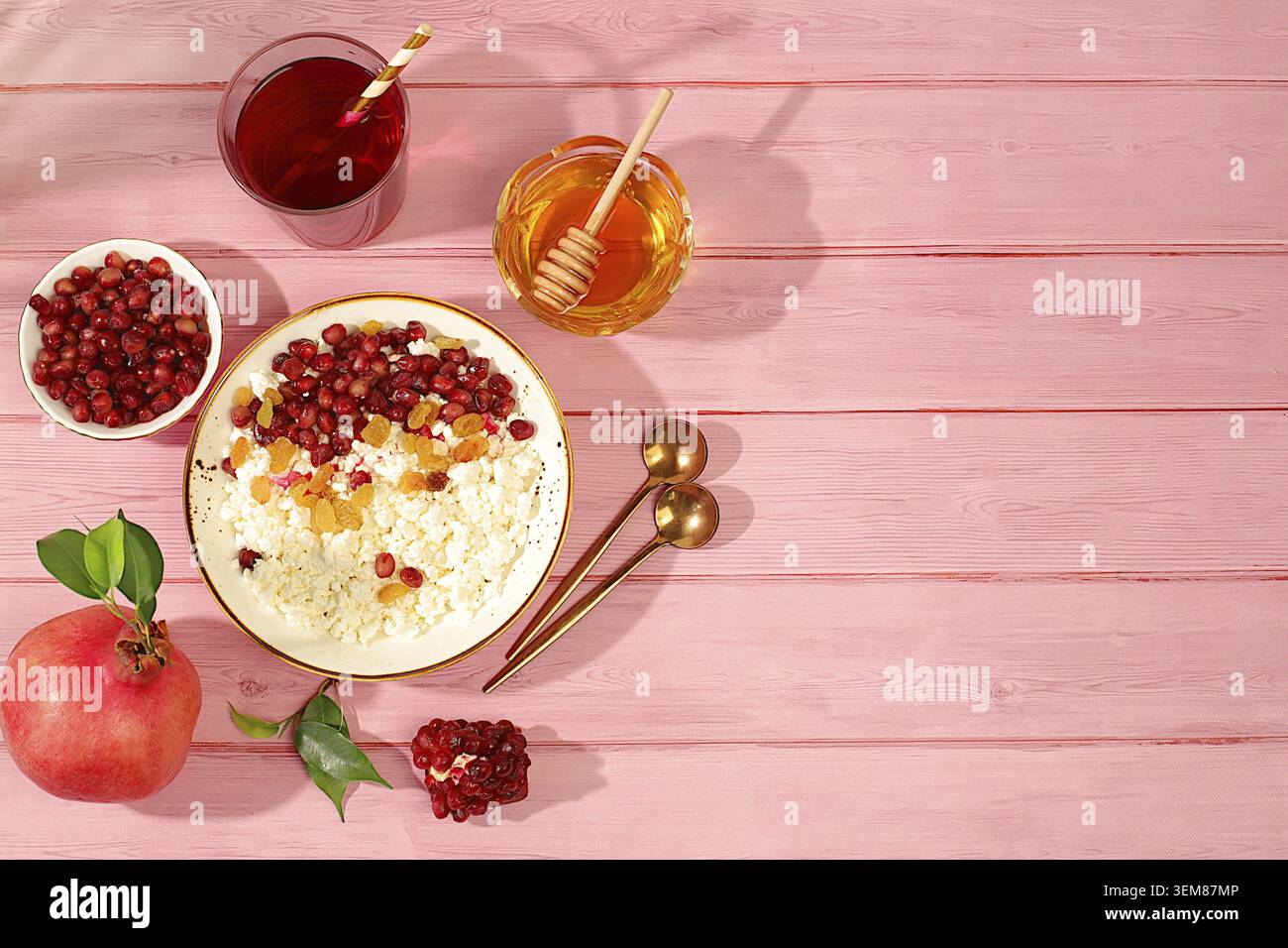 Körniger frischer Hüttenkäse mit Granatapfelsamen, Rosinen, Honig und Saft auf einem sonnigen Tisch, Entgiftungsdiät und natürliches Ernährungskonzept, gesundes LIFE Stockfoto