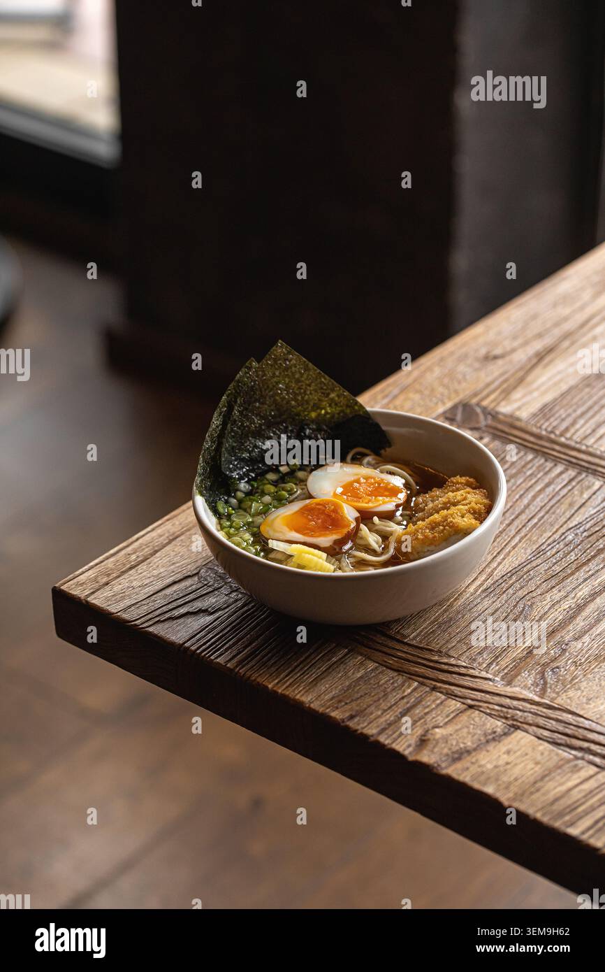 Japanische Ramen-Schüssel auf rustikalem Holztisch Stockfoto