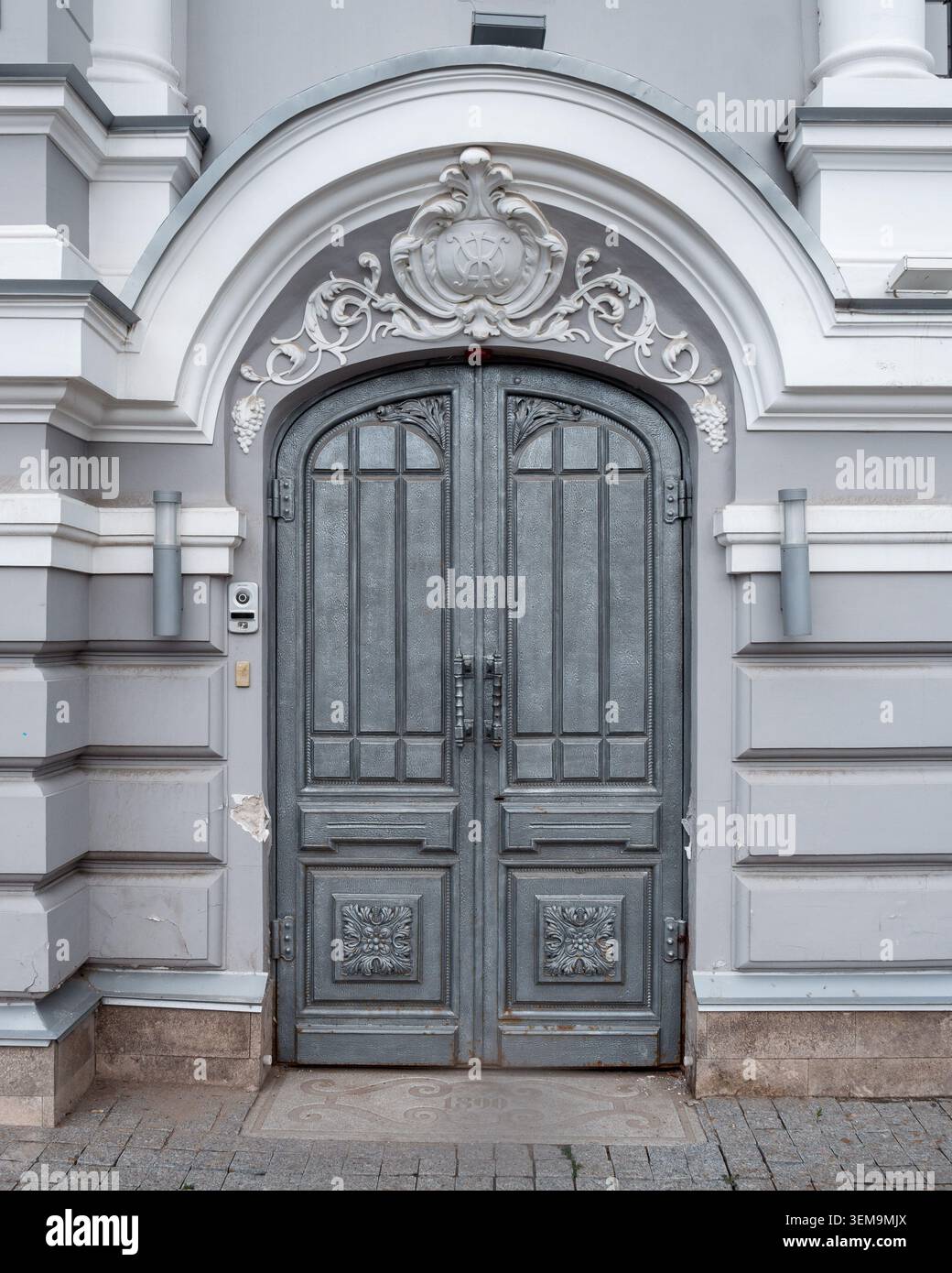 Historische dekorative Tür mit kunstvollen architektonischen Details an einer denkmalgeschützten Fassade. Stockfoto