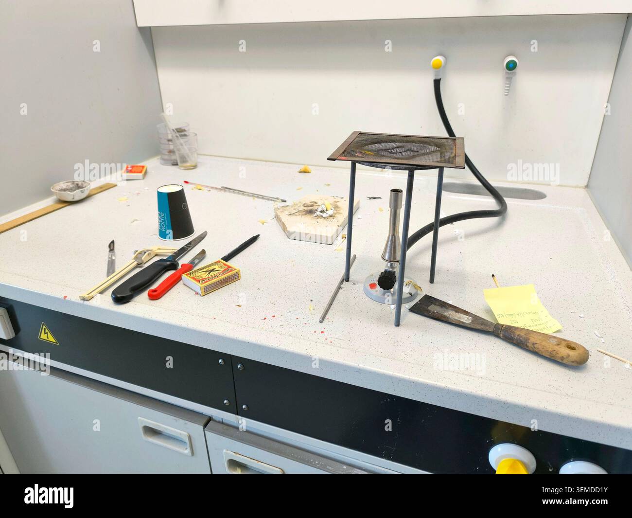 Laborwerkbank mit Bunsenbrenner Stativ, Werkzeugen und unordentlichem Chemistry Workspace for Research Stockfoto