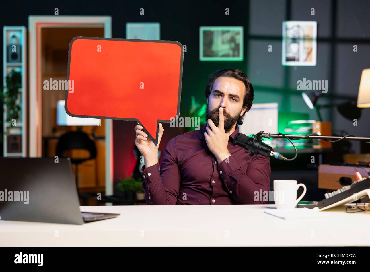 Influencer hält ein leeres Werbespot in der Hand und zeigt dem Publikum eine Botschaft, ohne zu sprechen. Internet-Star verwendet Sprechausschnitt aus roter Pappblase, um Meinungen ohne Stimme auszudrücken Stockfoto