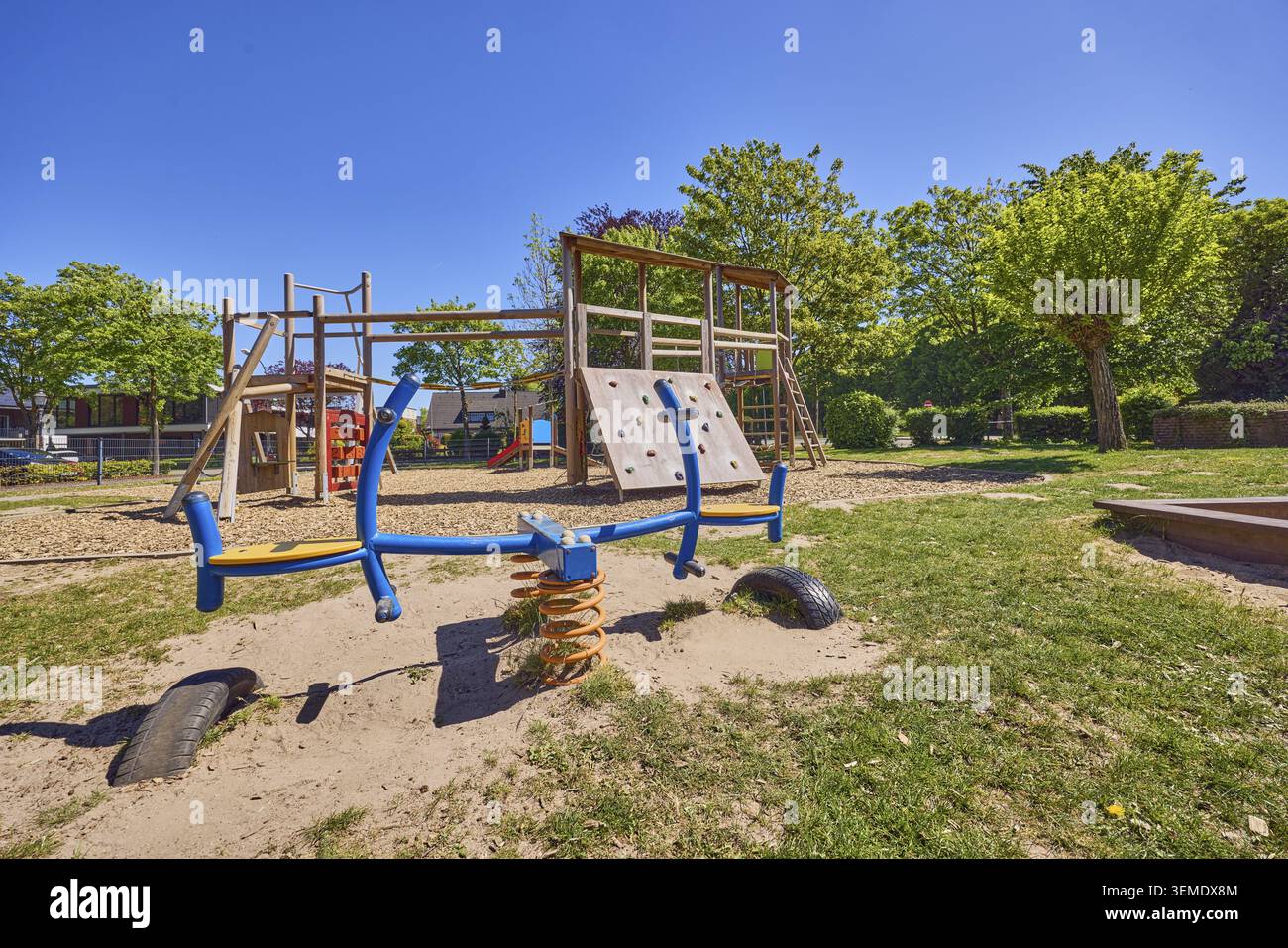 Wippe, Klettergerüst, Spielplatz, Park, Bäume, Hecke, Rasen, Sträucher, Froschperspektive, blauer Himmel, wolkenlos, Stadtweg, Uedem, Kleve District, Nordrhein-Westfalen Stockfoto