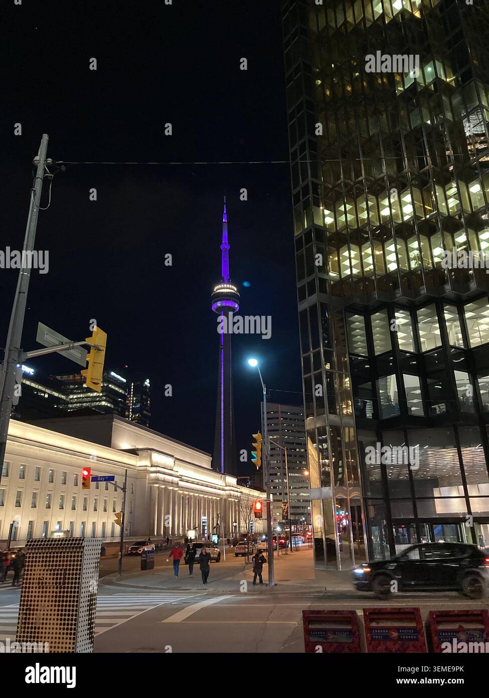 Nächtliche Straßenszene in der Innenstadt von Toronto mit violettem CN Tower im Hintergrund, Ontario, Kanada. Stockfoto