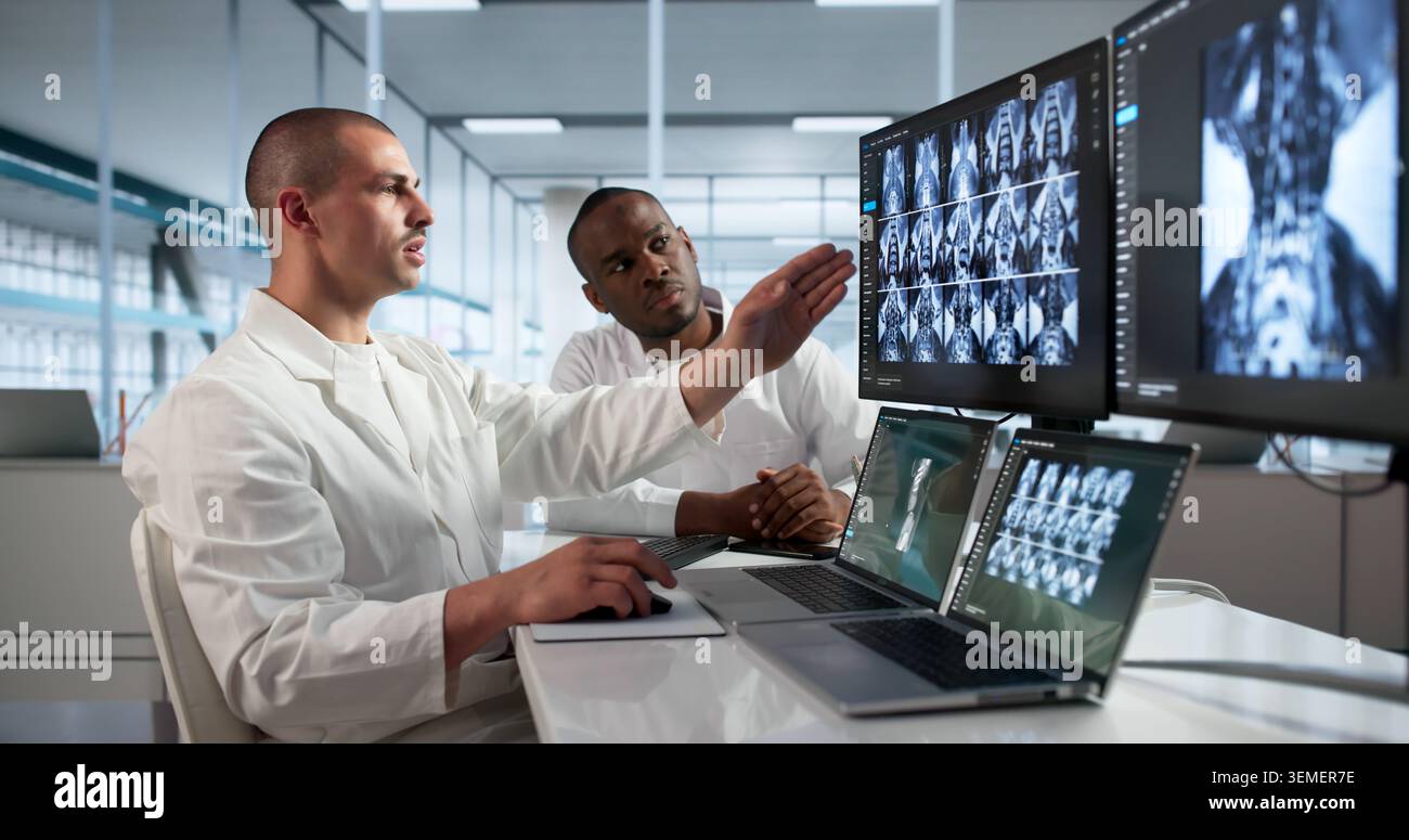 Ärzte, die Knie-Röntgenaufnahmen auf dem Desktop untersuchen, um die Schmerzursache des Patienten zu finden. Stockfoto