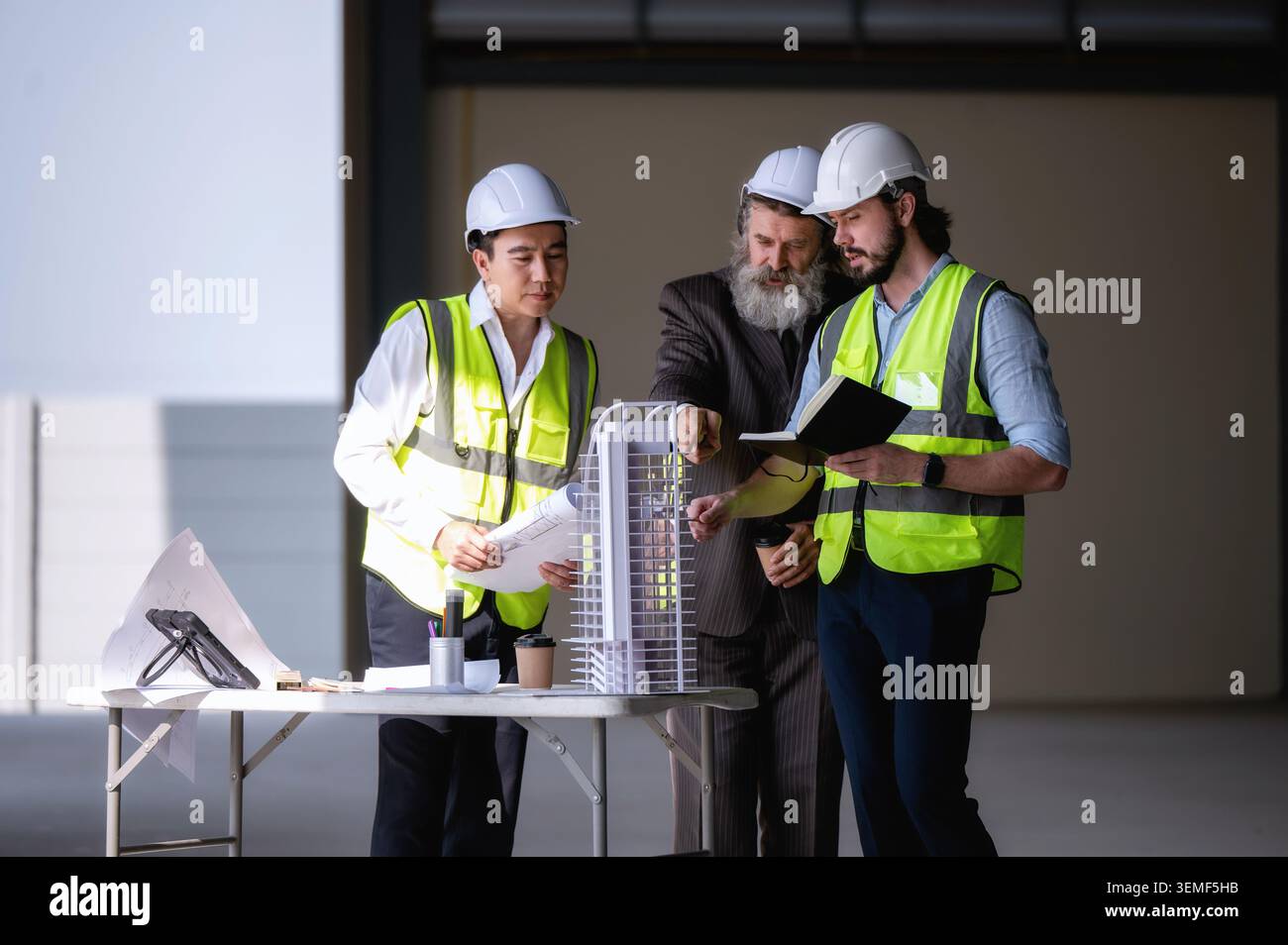 Besuch beim Investor bei der Überprüfung des architektonischen Layoutmodells leerer Standort, Ingenieure melden Fortschritt beim Bau von Wolkenkratzern, Investorenstandort vorübergehend Stockfoto