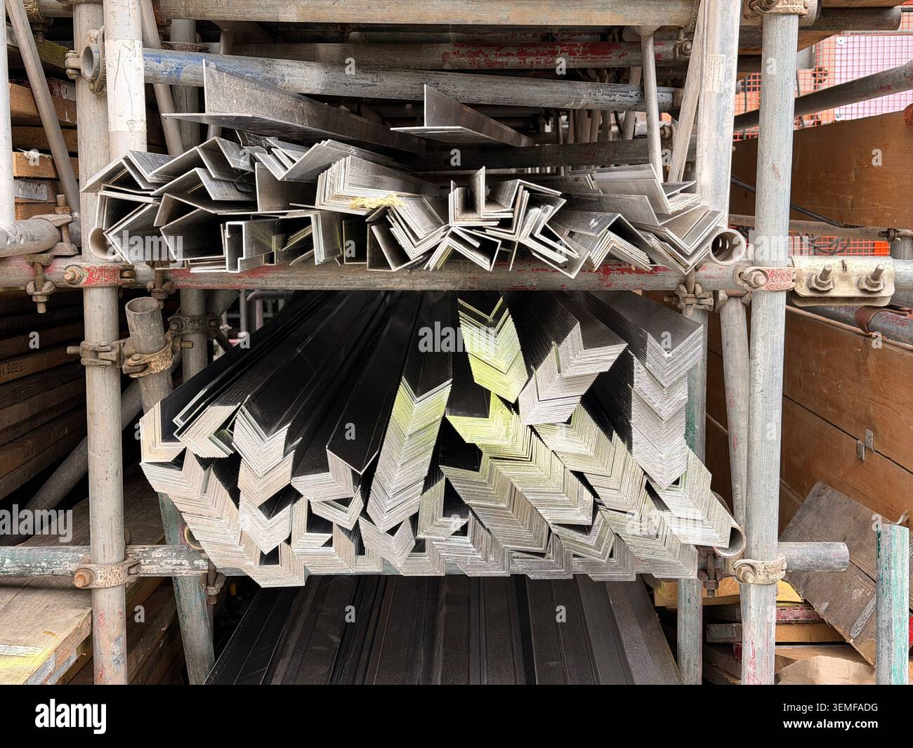 Organisierte Bündel von Metallwinkelstangen und -Kanälen auf Gerüstregalen. Stockfoto