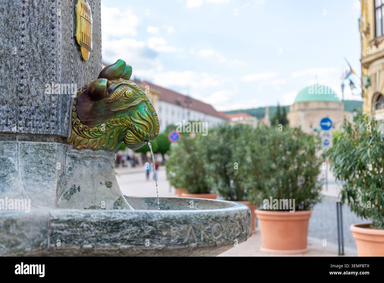 Pécs, Ungarn – 1. Mai 2026: Detail des Brunnens von Zsolnay mit der Moschee von Pascha Qasim im Hintergrund Stockfoto