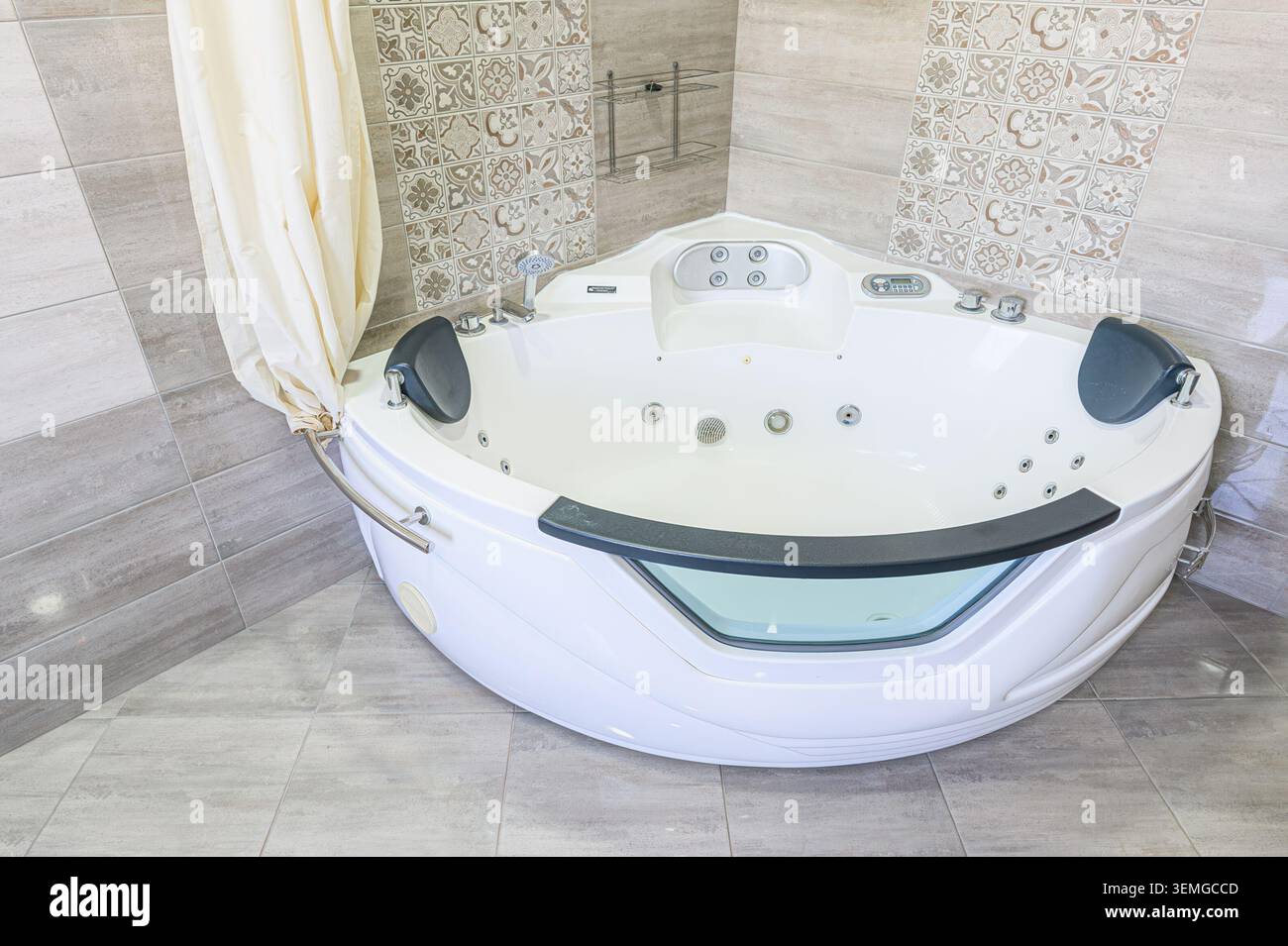 Eckbadewanne mit Vorhang und gemusterten Wandfliesen. Modernes Design mit integrierten Düsen Stockfoto