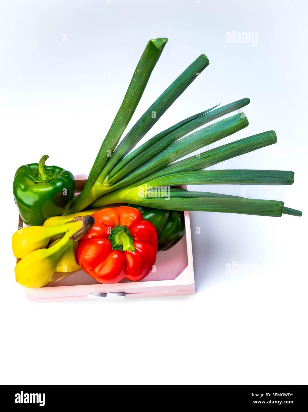 Frisches Gemüse auf weißem Hintergrund mit grünen Zwiebeln, Bananen und Paprika, saubere gesunde Produkte für Lebensmittel, Bio-Lebensmittel und Kochkonzept heute Stockfoto