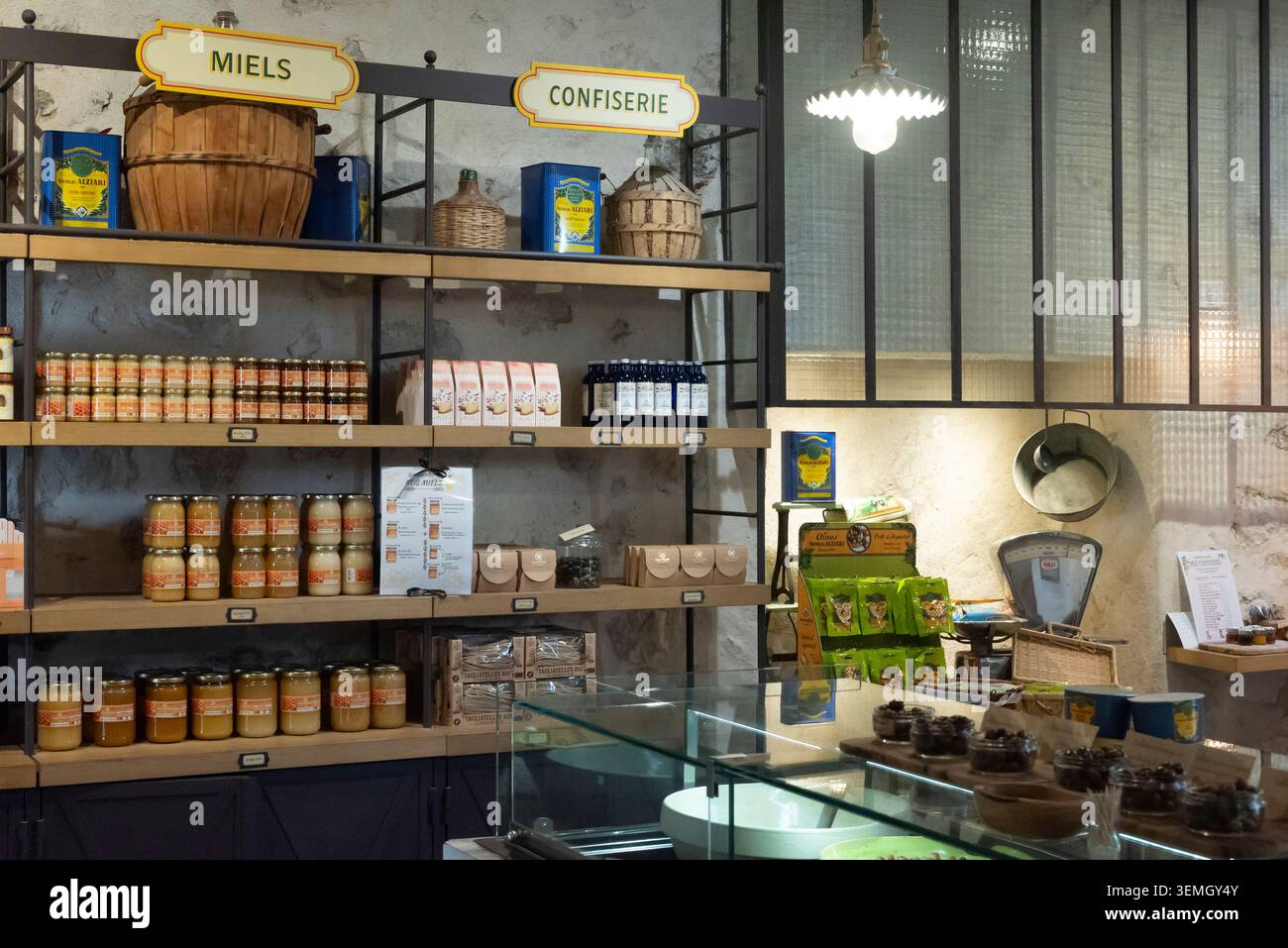 Nizza, Frankreich, 14. April 2026 Reihen von handgefertigten Alziari-Honiggläsern und Premium-Olivenölflaschen, wunderschön auf Holzregalen in einem Gourmet angeordnet Stockfoto
