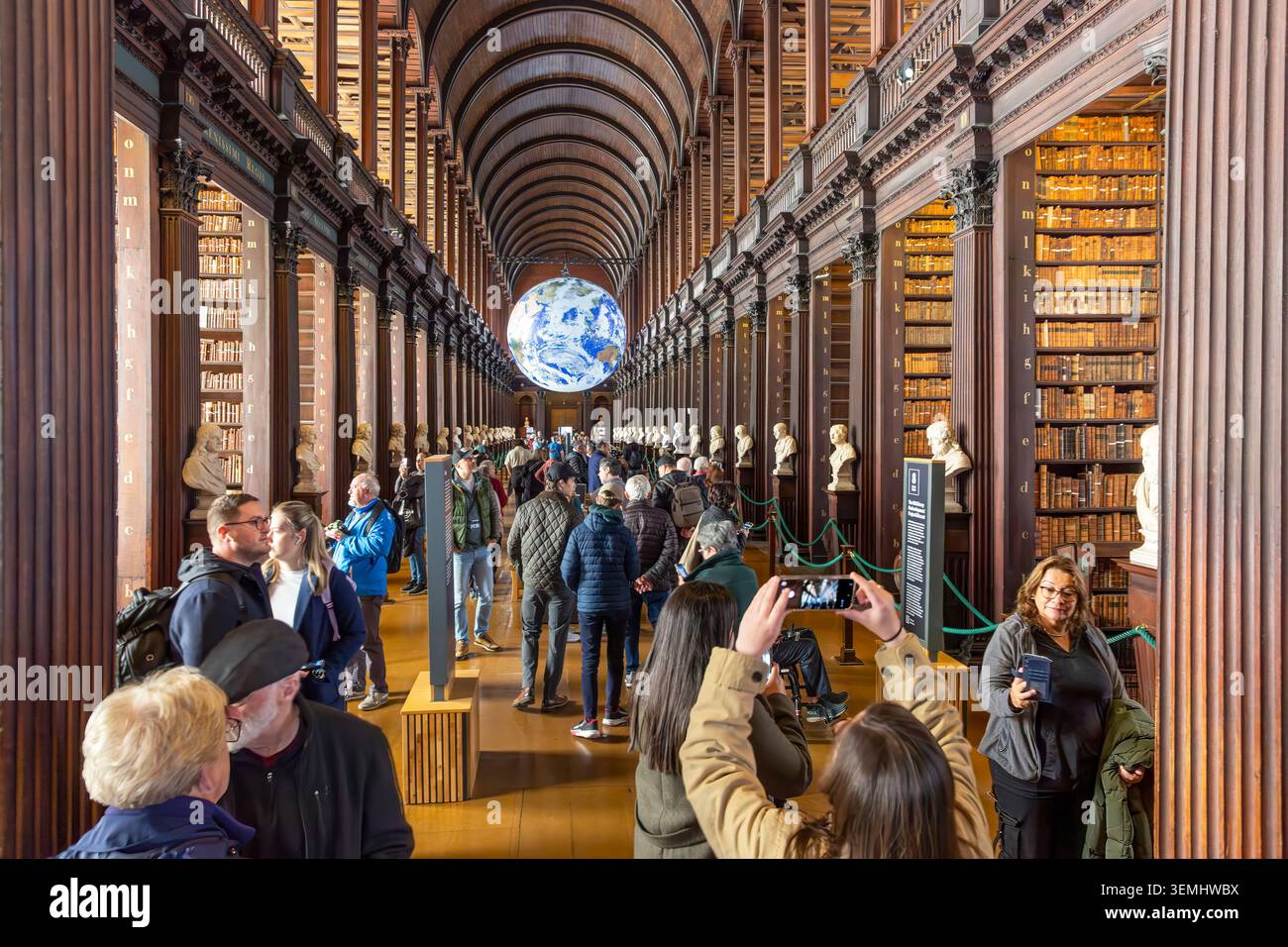 Touristen im Long Room der Old Library 1732 am Trinity College in Dublin, Irland. Die Bibliothek ist ein Beispiel klassischer Barockarchitektur d Stockfoto
