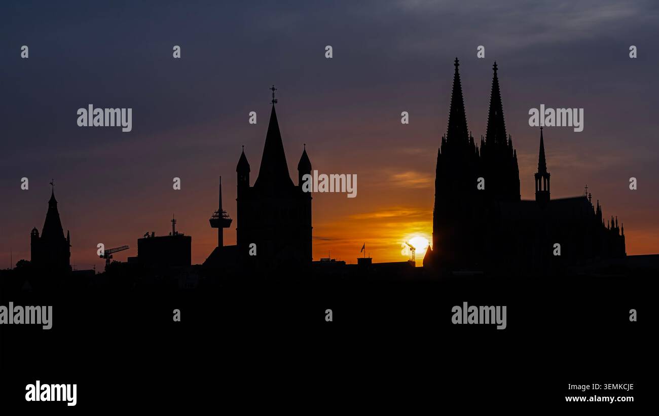 Silhouette des Kölner Doms und der historischen Rheintürme bei Sonnenuntergang in Köln, Deutschland, fotografiert am 30. Mai 2026, mit dramatischer Darstellung Stockfoto